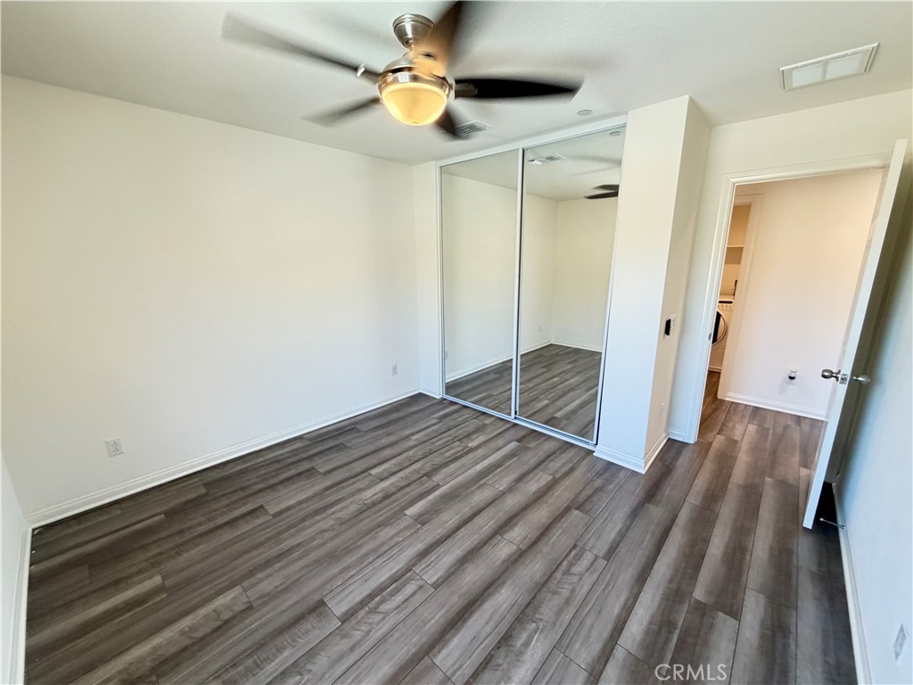 7483 Sage Scrub Road Riverside, CA 92507 - Photo 22 of 33 a view of an empty room with wooden floor and a ceiling fan