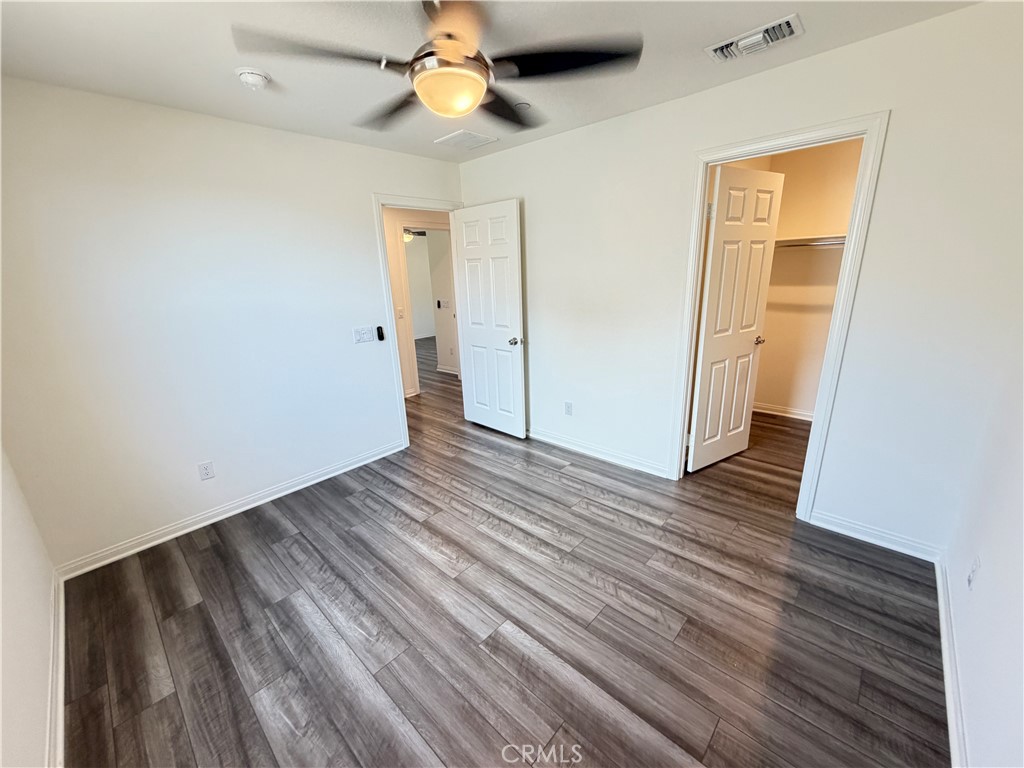 7483 Sage Scrub Road Riverside, CA 92507 - Photo 24 of 33 a view of an empty room with wooden floor and a ceiling fan