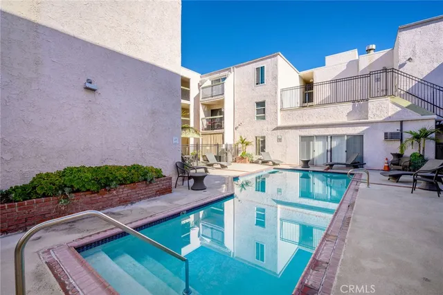 a view of a patio with couches table and chairs with wooden fence and plants