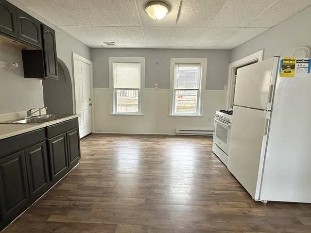 a view of a kitchen with wooden floor and a window