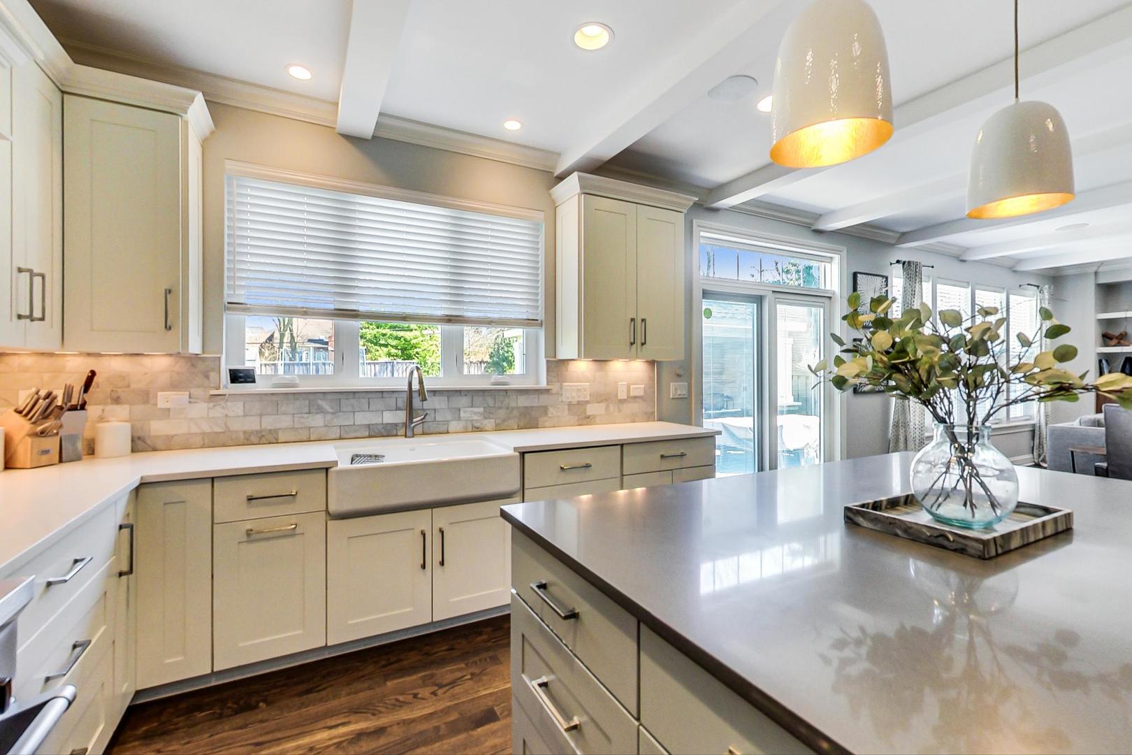 219 Clinton Avenue Elmhurst, IL 60126 - Photo 16 of 49 a kitchen with kitchen island granite countertop a sink a counter top space and living room view