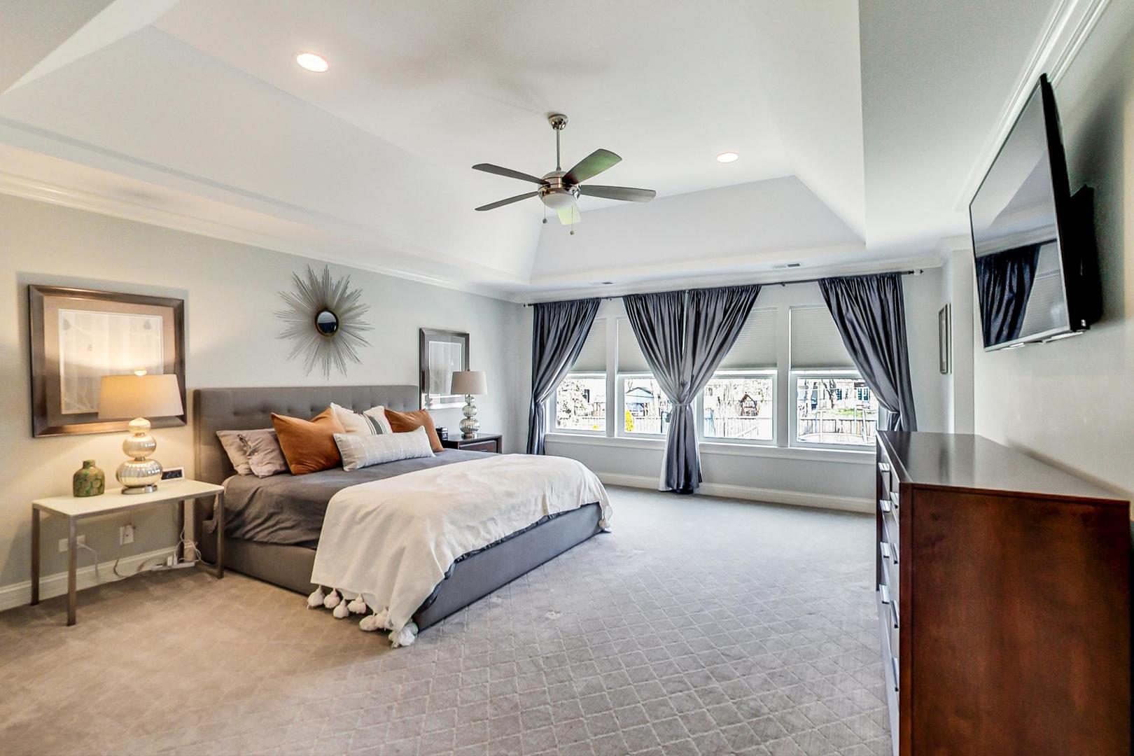 219 Clinton Avenue Elmhurst, IL 60126 - Photo 21 of 49 a spacious bedroom with a balcony a bed and a flat tv screen on dresser
