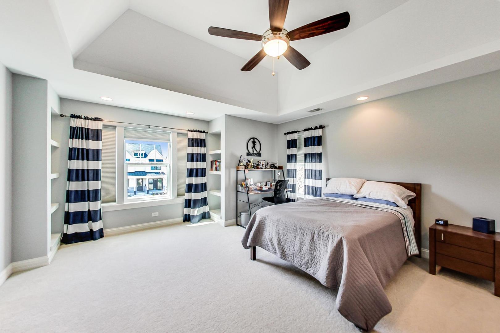 219 Clinton Avenue Elmhurst, IL 60126 - Photo 25 of 49 a spacious bedroom with a bed a dresser and a book shelf