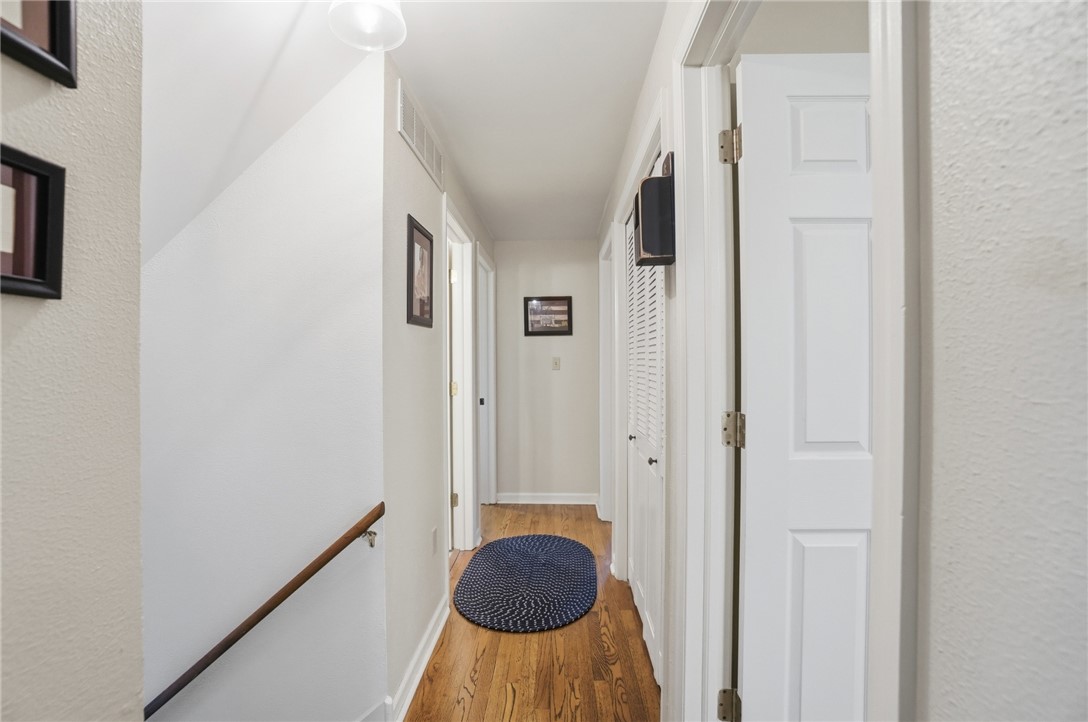 4170 Johnson Road Springfield, OH 45502 - Photo 34 of 54 Hardwood flooring extends through this well-lit hallway with natural wood handrails and classic panel doors.