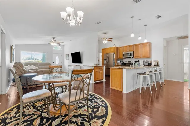 a view of a dining room with furniture a chandelier and wooden floor