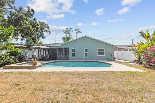 a view of a house with backyard and sitting area