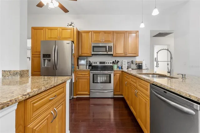 a kitchen with stainless steel appliances granite countertop a sink a stove and refrigerator