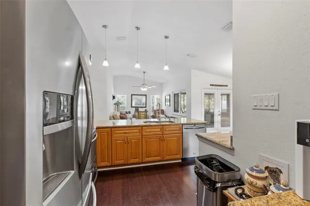 a kitchen with stainless steel appliances granite countertop a refrigerator and a stove top oven