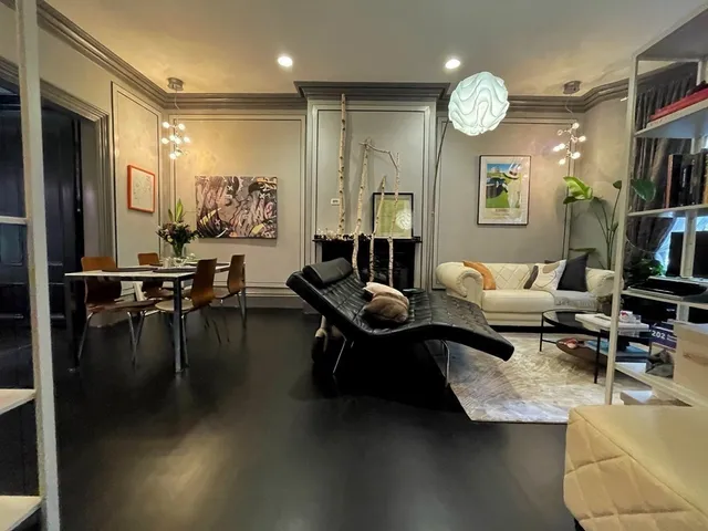 a living room with fireplace furniture and a view of kitchen