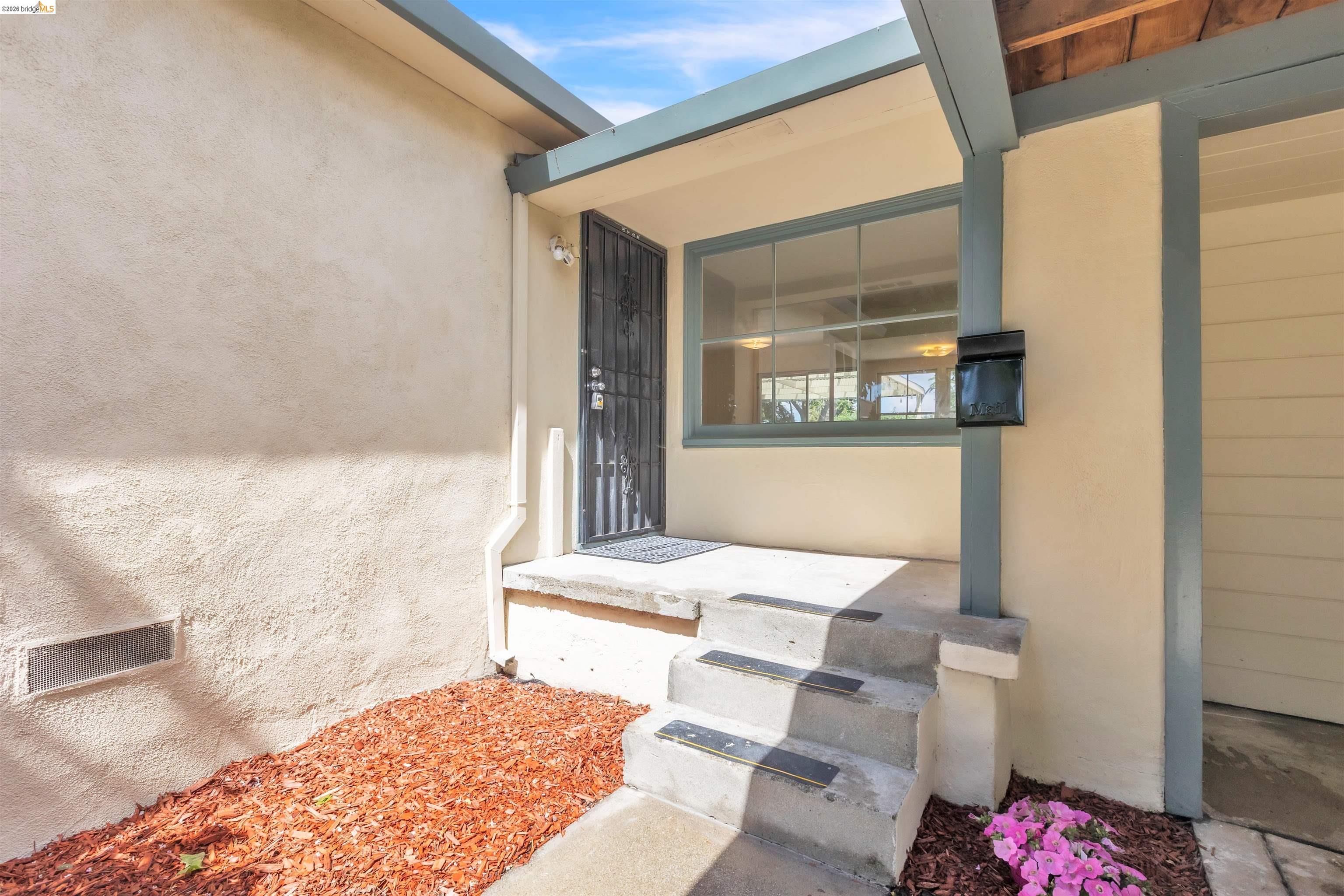621 Paseo Del Rio San Lorenzo, CA 94580 - Photo 2 of 24 Entryway featuring concrete steps, stucco siding, a security screen door, and an exterior window