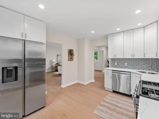 a kitchen with stainless steel appliances granite countertop a refrigerator and a stove top oven