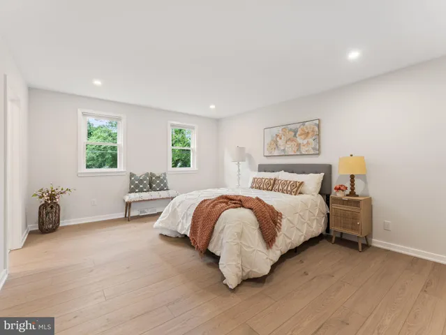 a spacious bedroom with a bed and wooden floor