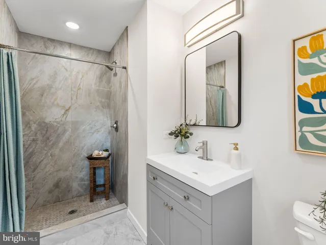 a bathroom with a shower sink and mirror