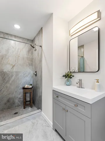 a bathroom with a sink mirror and a shower