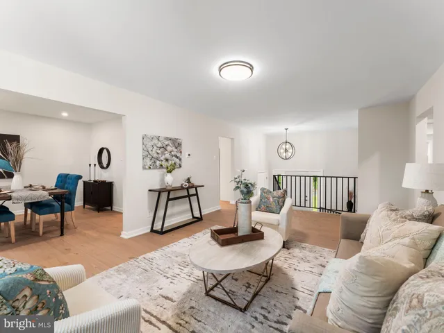 a living room with furniture a wooden floor and next to a window