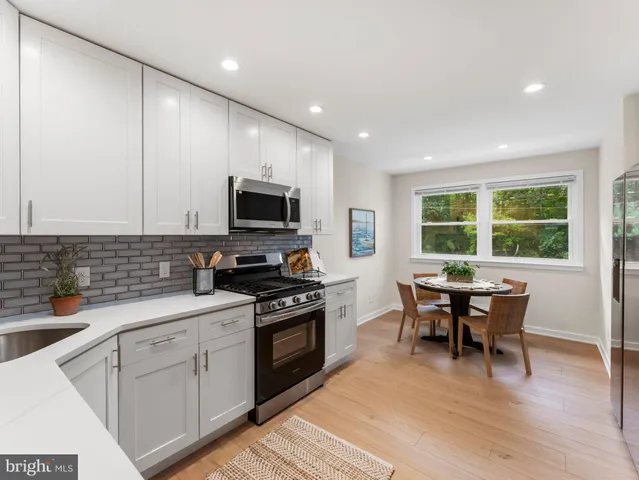 a kitchen with a sink wooden cabinets and stainless steel appliances