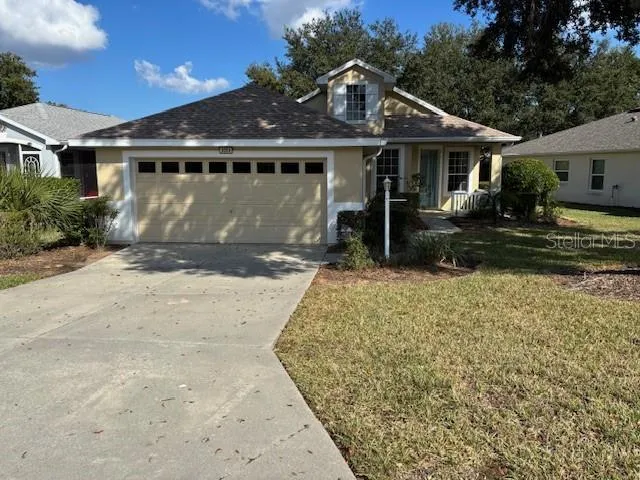 a front view of a house with a yard and potted plants