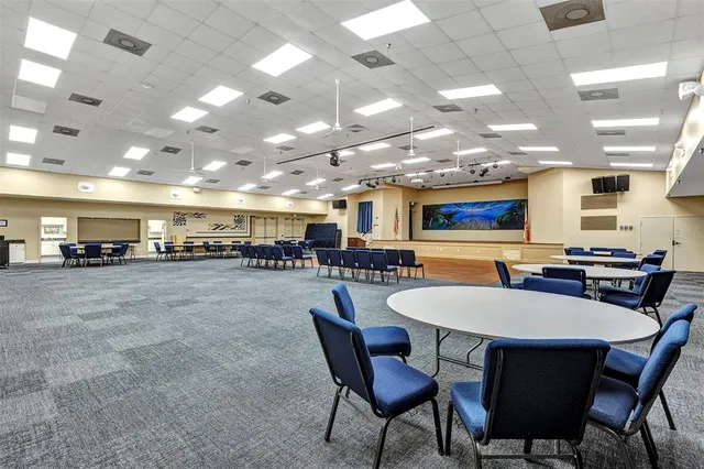 a room with stainless steel appliances lots of white furniture and a dining table
