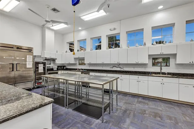 a kitchen with stainless steel appliances granite countertop a stove top oven a sink dishwasher and cabinets with wooden floor