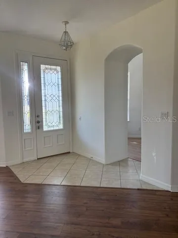 an empty room with wooden floor cabinet and windows