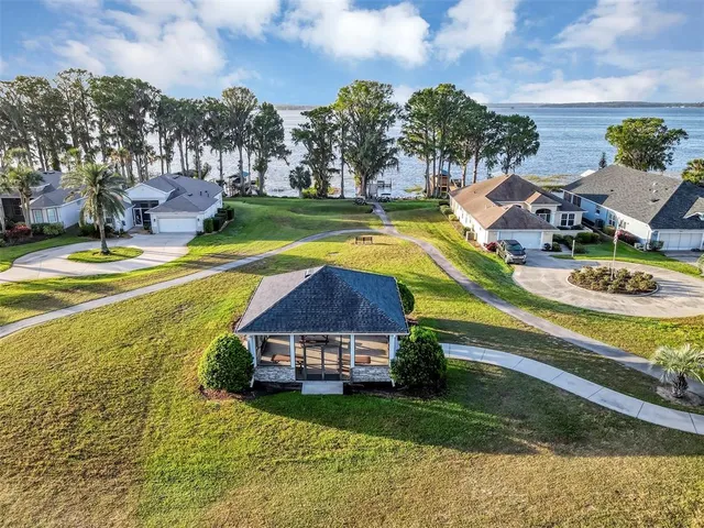 a view of a swimming pool with lawn chairs and a big yard