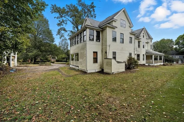 a view of a white house with a yard