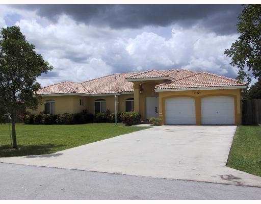 a front view of a house with a garden and yard