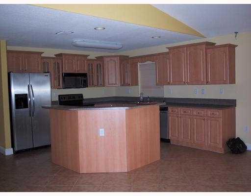 17241 Southwest 285th Street Homestead, FL 33030 - Photo 2 of 14 a kitchen with stainless steel appliances granite countertop a refrigerator a stove and a sink with wooden cabinets