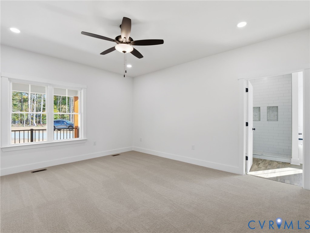 4301 Worsham Road Powhatan, VA 23139 - Photo 21 of 33 an empty room with a ceiling fan and windows