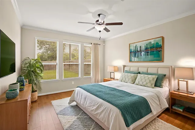 an empty room with wooden floor and a ceiling fan