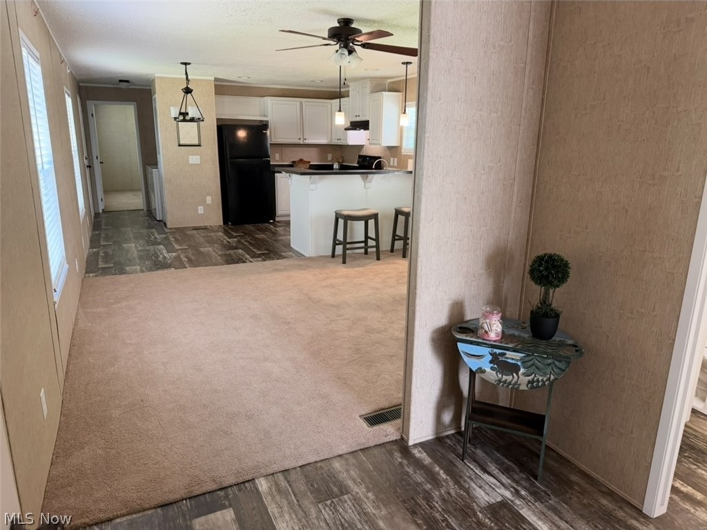 202 West Main Road, Unit 139 Conneaut, OH 44030 - Photo 39 of 45 Open-concept living space featuring a kitchen with white cabinetry, black appliances, and a central island with bar seating