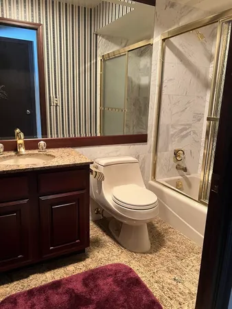 a bathroom with a granite countertop sink toilet a mirror and shower