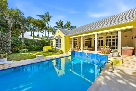 a view of swimming pool with garden and patio