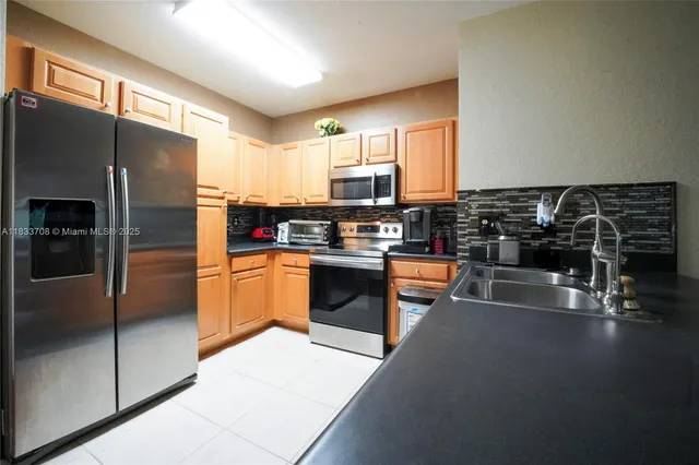 a kitchen with stainless steel appliances a refrigerator a stove a sink and a microwave