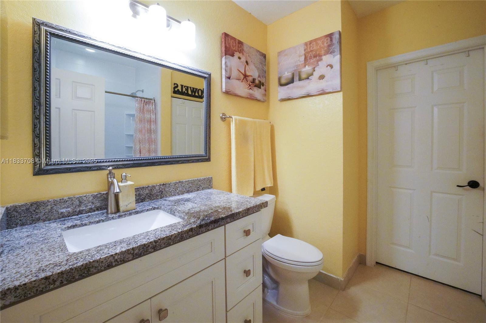 3335 Palomino Drive Davie, FL 33024 - Photo 18 of 31 a bathroom with a granite countertop sink mirror vanity and toilet