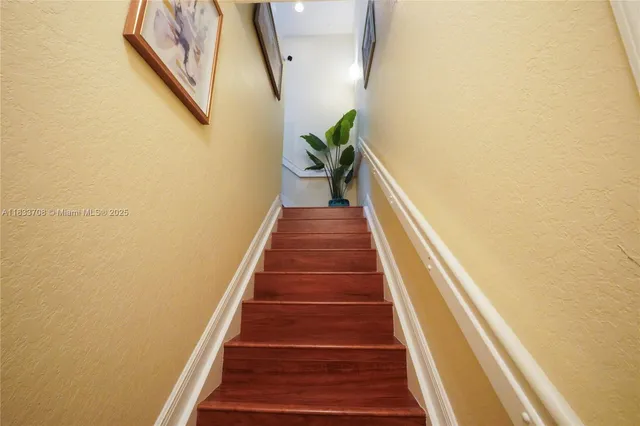 a view of a hallway with wooden floor and stairs