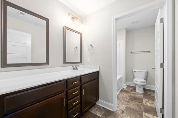 a bathroom with a sink a toilet and a mirror