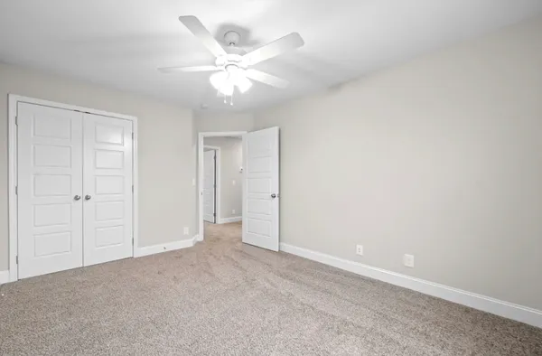 an empty room with a chandelier fan