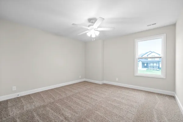 an empty room with a window and a fan