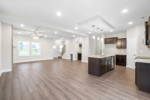 a view of kitchen with cabinets stainless steel appliances and wooden floor