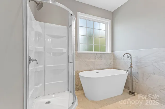 a white bath tub sitting next to a shower