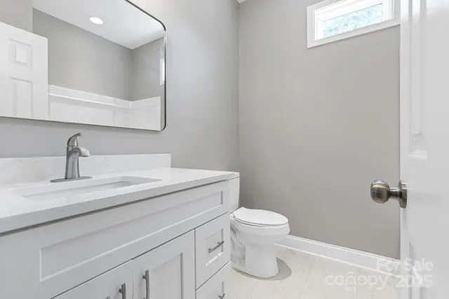 a bathroom with a granite countertop toilet and sink