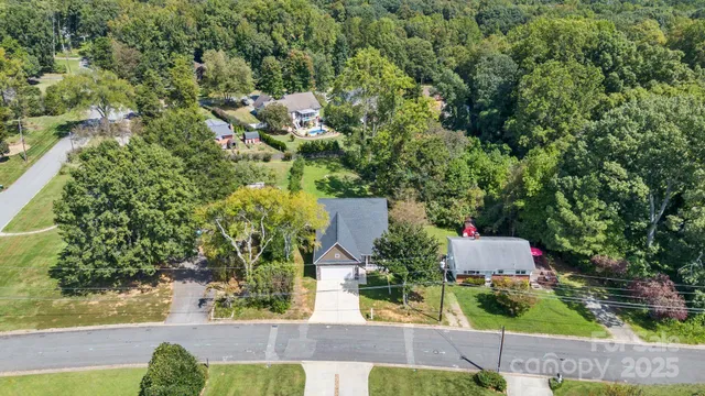an aerial view of residential house with outdoor space and trees all around