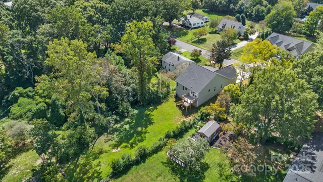 an aerial view of residential house with outdoor space and trees all around