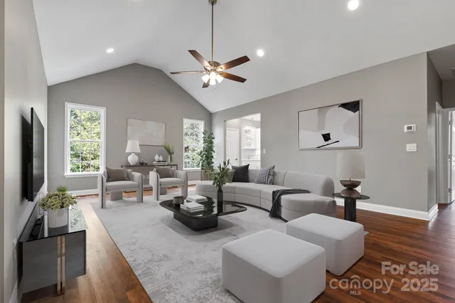 a living room with furniture kitchen view and a large window