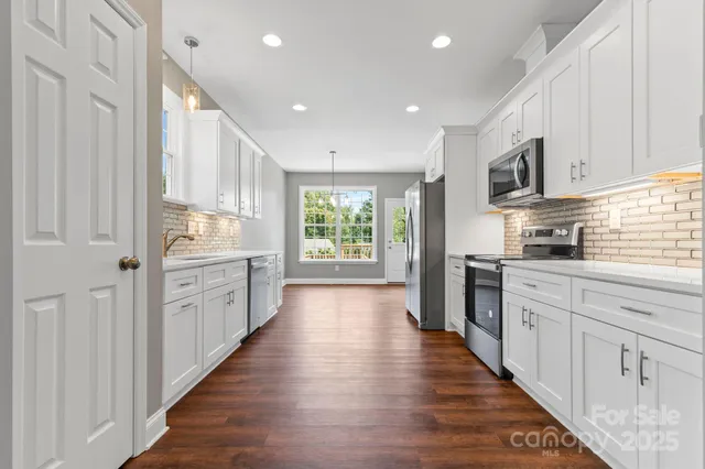 a kitchen with stainless steel appliances sink refrigerator and microwave