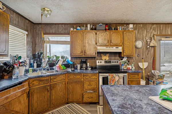 a kitchen with stainless steel appliances granite countertop a stove a sink and a microwave