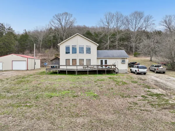 a front view of a house with a yard and car parked
