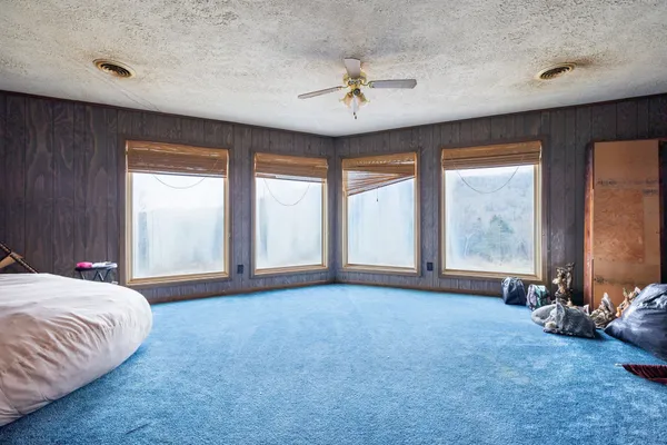a spacious bedroom with a bed and a large window