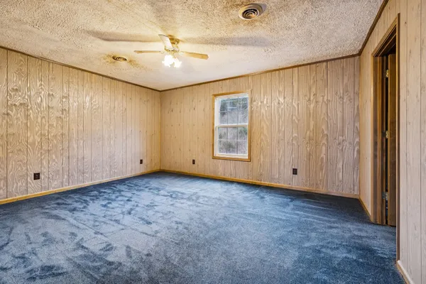 an empty room with windows and closet area